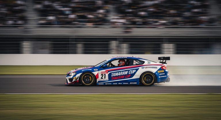 Tamaraw-branded race car on a Philippine circuit with fans and crew